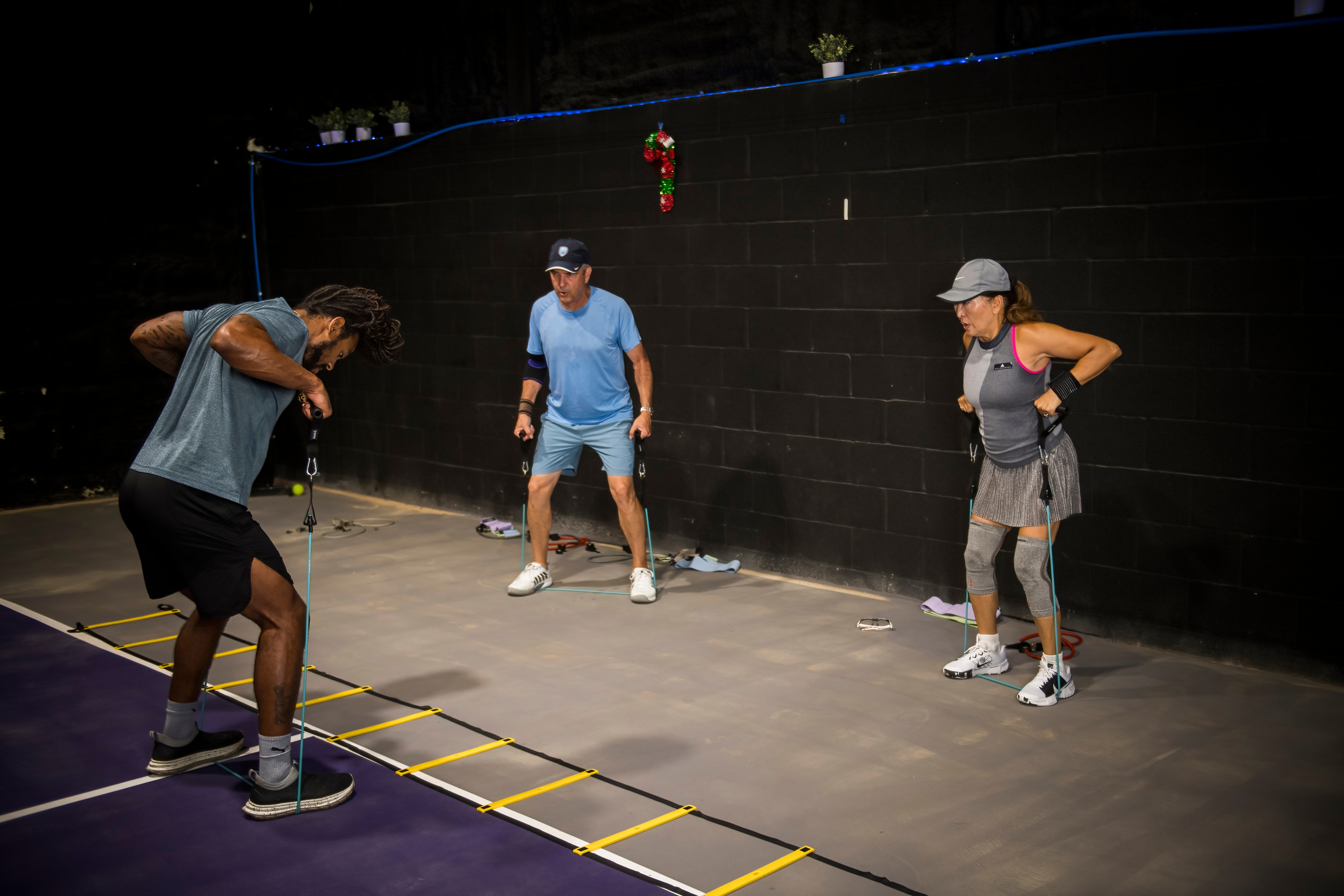 Athletes doing ladder agility drills on a racket court